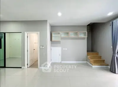 Modern minimalist interior with staircase and glass door, ideal for open living space.