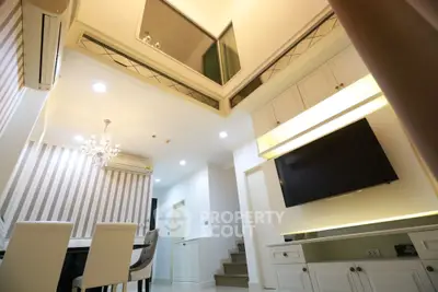 Modern interior with high ceiling, elegant dining area, and stylish lighting