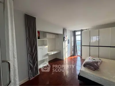 Spacious bedroom with large windows and modern furnishings, offering abundant natural light and city views.