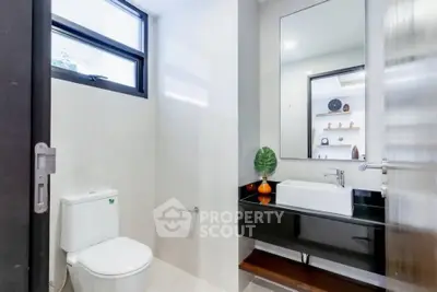 Modern bathroom with sleek fixtures and large mirror in a bright, minimalist design.