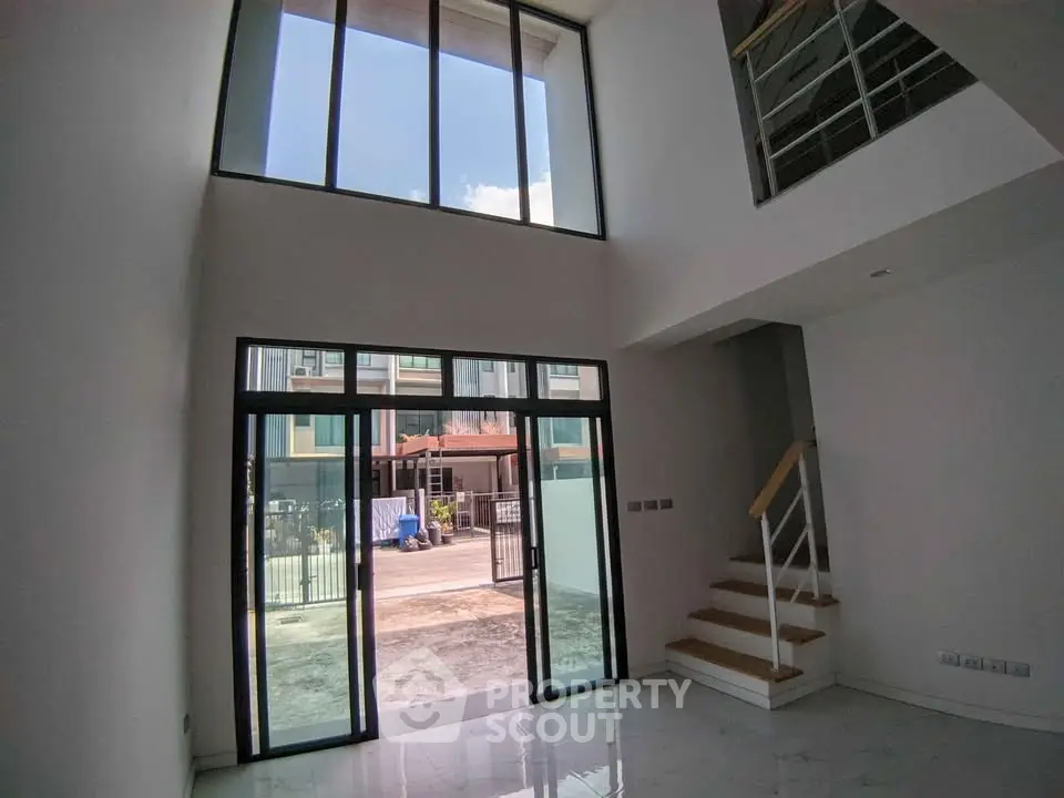 Spacious modern living room with high ceiling and large windows