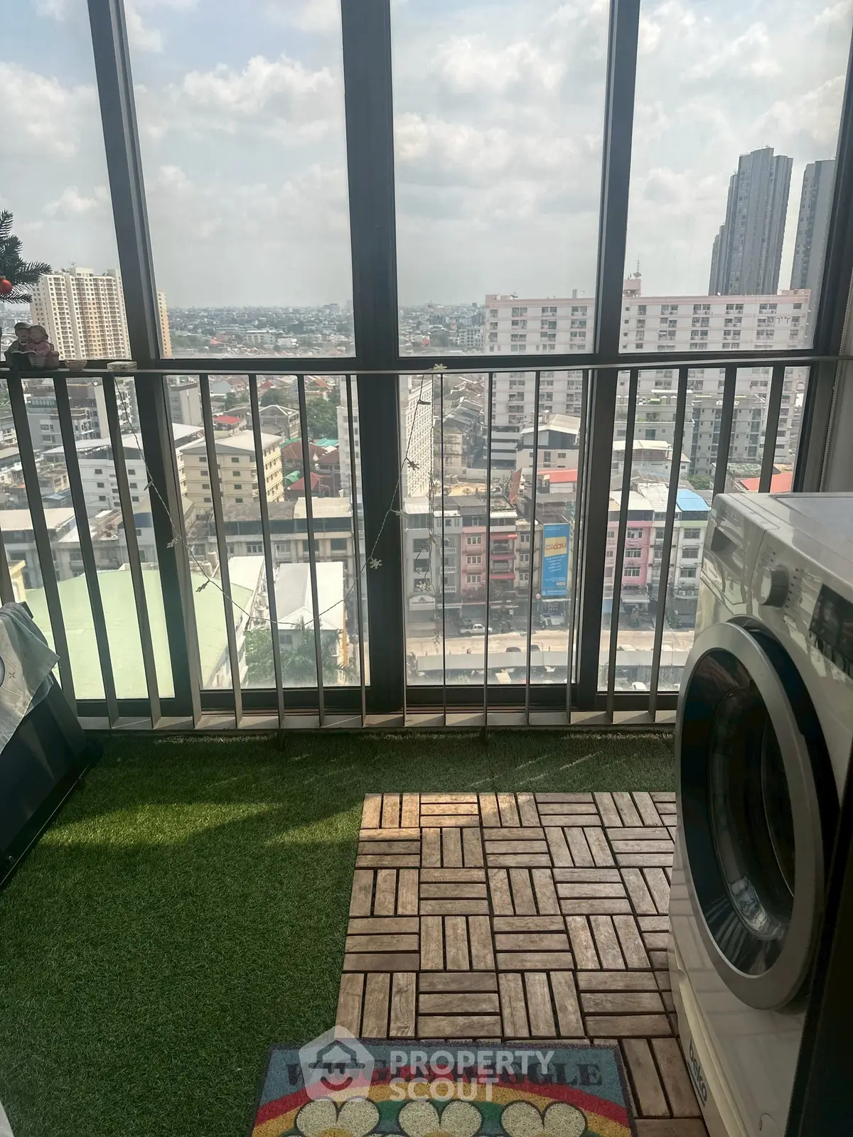 High-rise balcony with city view and washing machine, perfect for urban living.