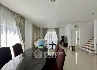 Spacious living room with elegant dining area and natural light