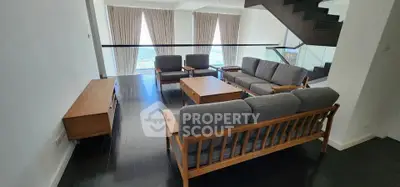 Spacious living room with modern furniture and large windows offering stunning views.