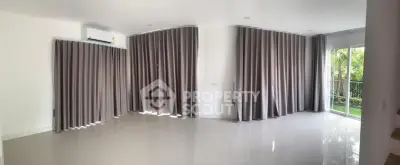 Spacious living room with large windows and modern curtains, offering a bright and airy atmosphere.