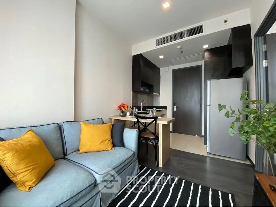 Modern living room with cozy sofa and open kitchen layout in stylish apartment.