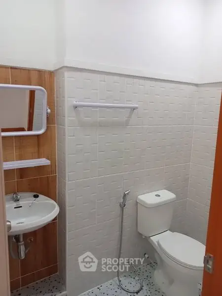 Modern bathroom with sleek fixtures and tiled walls, featuring a compact design.
