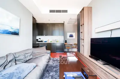 Modern living room with open kitchen, sleek furniture, and stylish decor in a contemporary apartment.