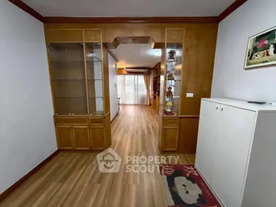 Spacious living area with wooden flooring and built-in cabinets, perfect for modern living.