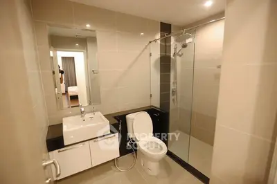 Modern bathroom with glass shower and sleek fixtures in contemporary apartment.