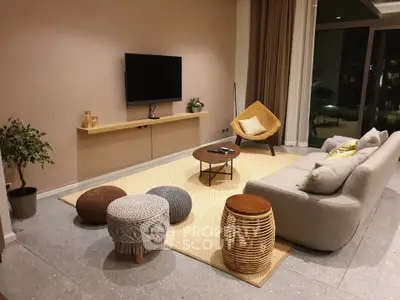 Stylish modern living room with cozy seating and wall-mounted TV, perfect for relaxation and entertainment.