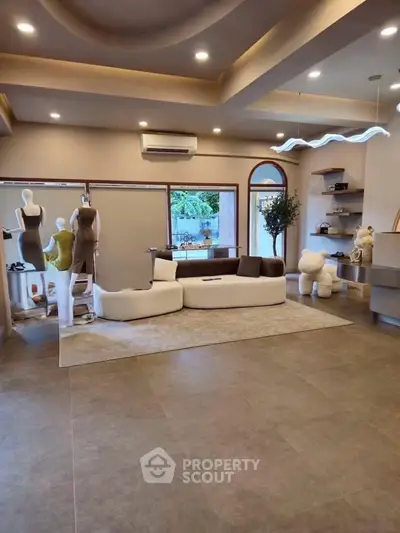 Spacious modern living room with stylish decor and large window view.