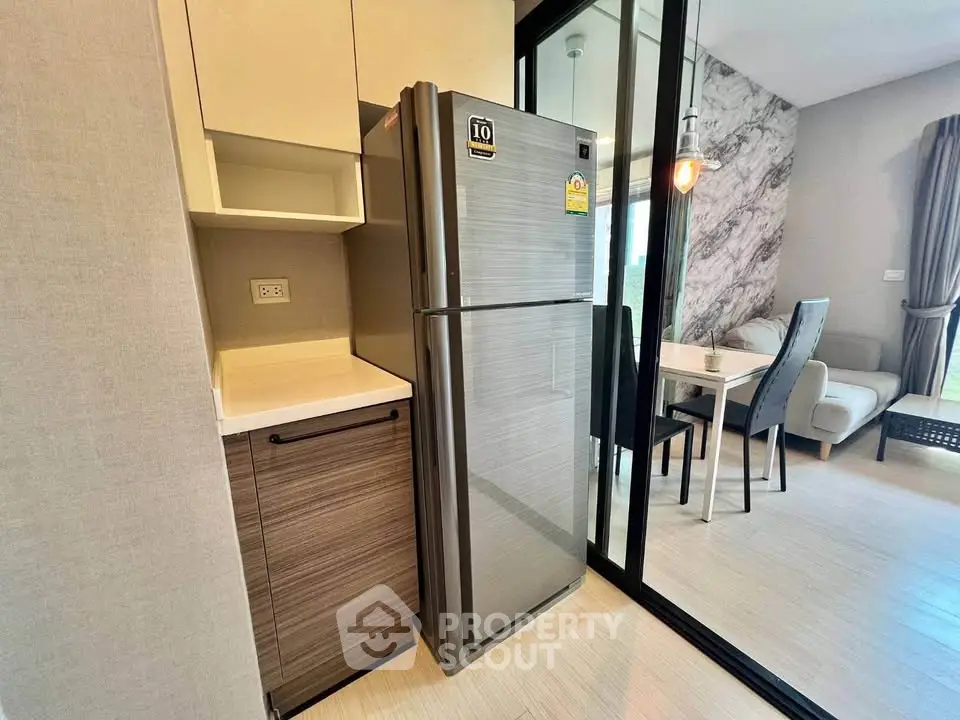 Modern kitchen with stainless steel fridge and dining area in stylish apartment
