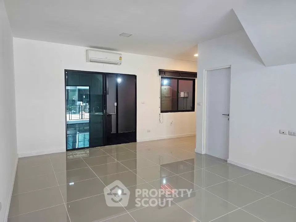Spacious modern living room with sleek tiled floors and large windows