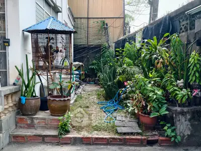 Charming garden area with lush greenery and potted plants, perfect for relaxation and outdoor enjoyment.