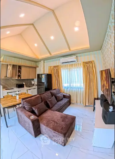 Modern living room with stylish decor, open kitchen layout, and cozy seating area, perfect for relaxation and entertainment.