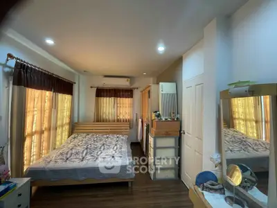Cozy bedroom with wooden flooring and ample natural light