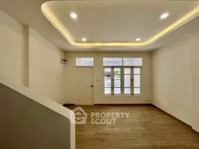 Spacious modern living room with elegant ceiling lights and wooden flooring