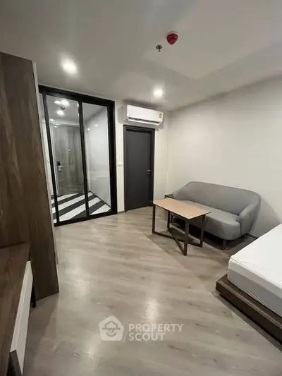 Modern minimalist bedroom with sleek furniture and wooden flooring