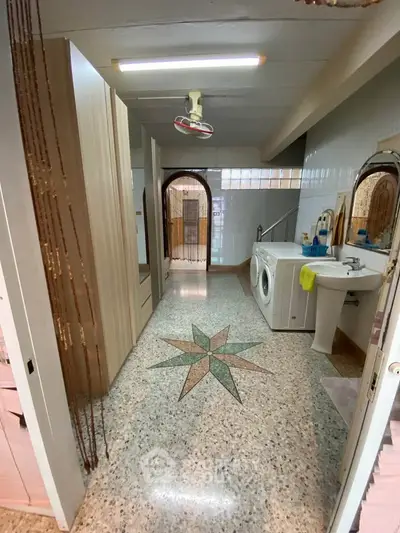 Spacious bathroom with washing machine and unique floor design