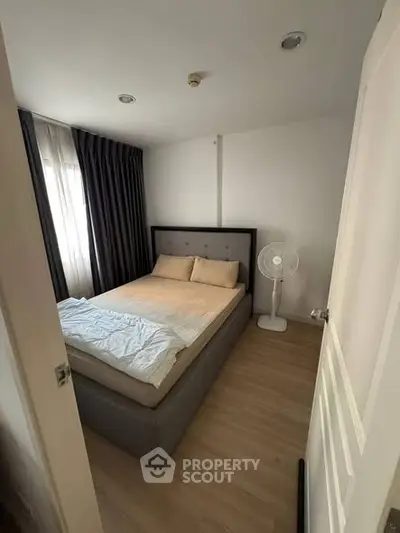 Cozy bedroom with modern decor and natural light, featuring a comfortable bed and stylish curtains.