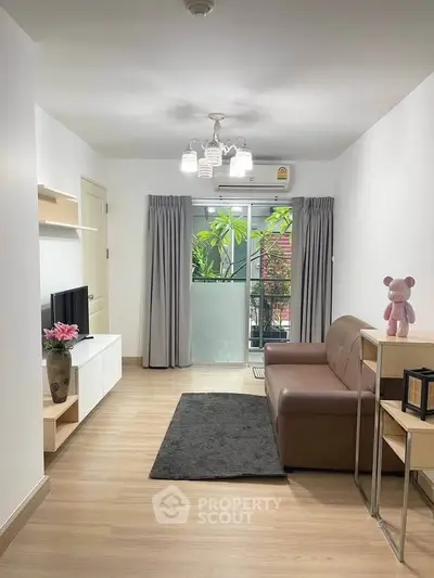 Modern living room with balcony view, stylish decor, and ample natural light.