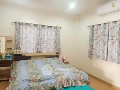 Cozy bedroom with floral curtains and air conditioning in modern apartment.
