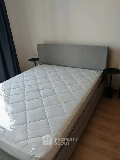 Modern bedroom with a stylish gray bed frame and comfortable mattress, perfect for a cozy retreat.