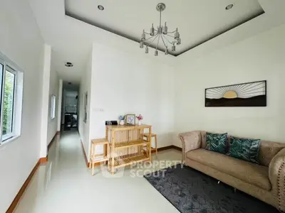 Elegant living room with modern chandelier and cozy sofa in a bright, minimalist home interior.