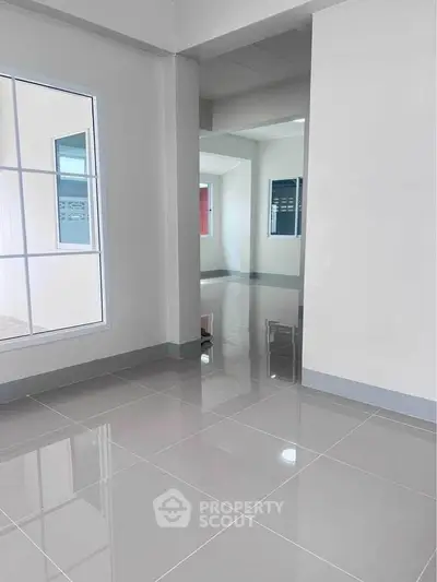 Spacious modern interior with glossy tiled floors and large windows