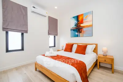 Modern bedroom with stylish decor and natural light, featuring a cozy bed and contemporary artwork.