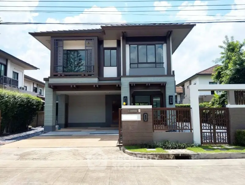 Modern two-story house with sleek design and spacious driveway in a suburban neighborhood.