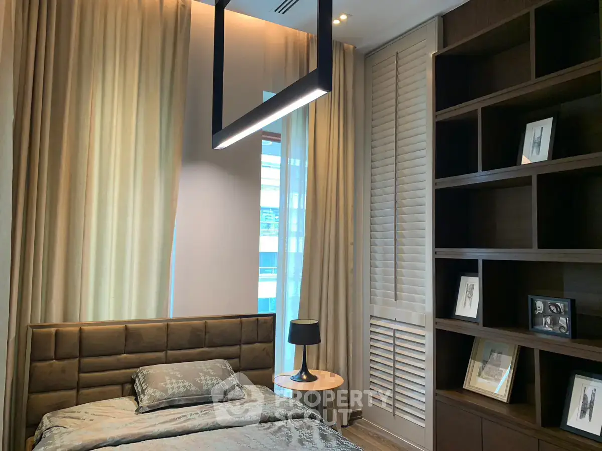 Luxurious bedroom with modern lighting and elegant shelving in a high-end apartment.