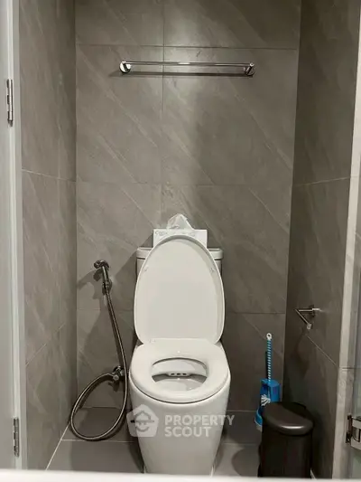 Modern bathroom with sleek tile design and essential fixtures, perfect for contemporary living.