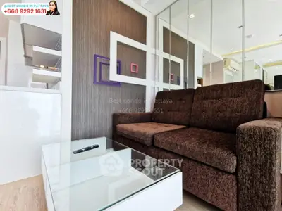 Modern living room with stylish brown sofa and glass coffee table in Pattaya condo