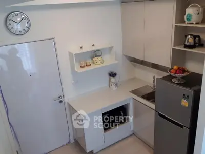 Modern compact kitchen with sleek cabinets and stainless steel fridge