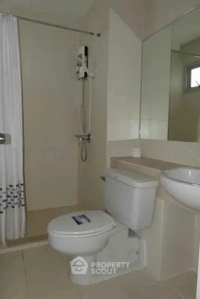 Modern bathroom with shower and toilet in a minimalist design.