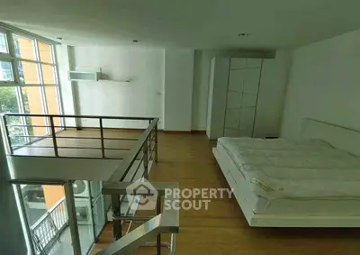 Spacious loft bedroom with modern design and large windows for natural light