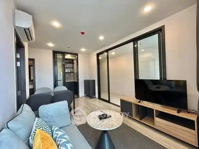 Modern living room with sleek furniture and large TV in stylish apartment.