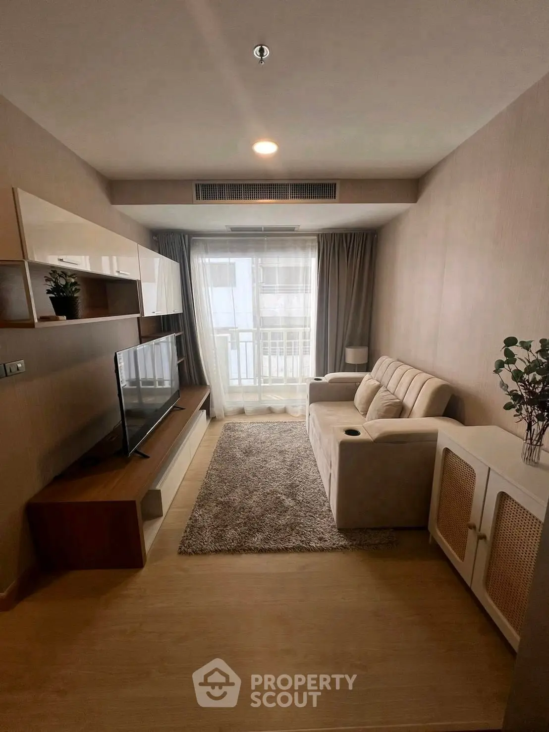 Modern living room with cozy sofa, TV unit, and large window for natural light.