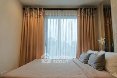 Cozy bedroom with large window and elegant curtains in modern apartment.
