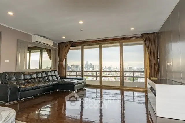 Spacious living room with panoramic city view and sleek leather sofa.