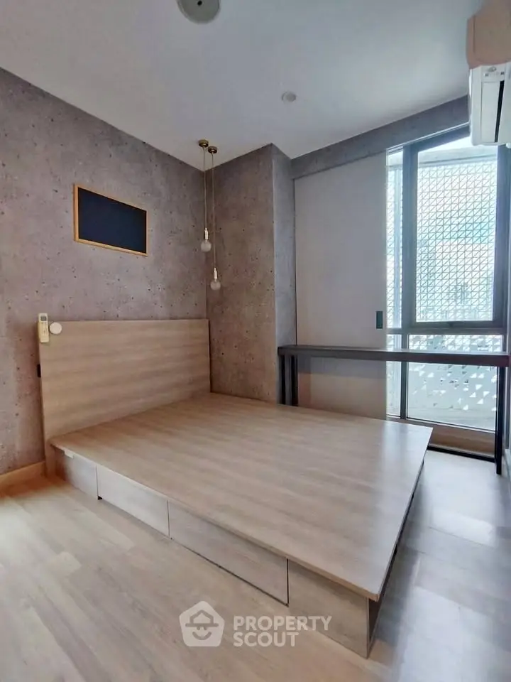 Modern minimalist bedroom with built-in storage and large window for natural light.