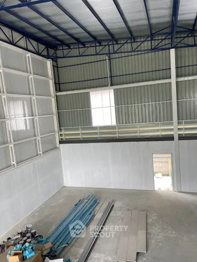 Spacious industrial warehouse interior with high ceilings and ample storage space.