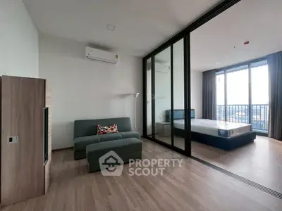Modern apartment with glass partition, cozy living area, and spacious bedroom with city view.