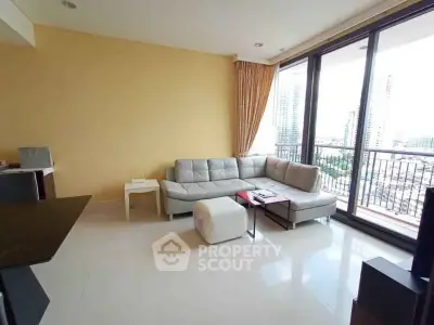 Spacious living room with large windows and city view, featuring modern furniture and elegant decor.