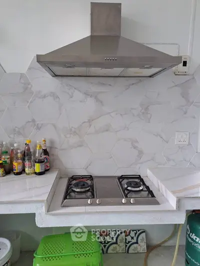 Modern kitchen with gas stove and stylish hexagonal backsplash tiles