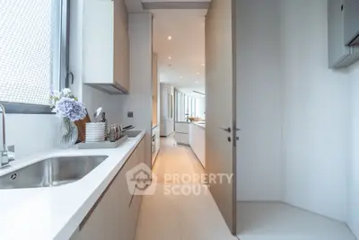 Modern kitchen with sleek design and open layout, featuring stainless steel sink and elegant cabinetry.