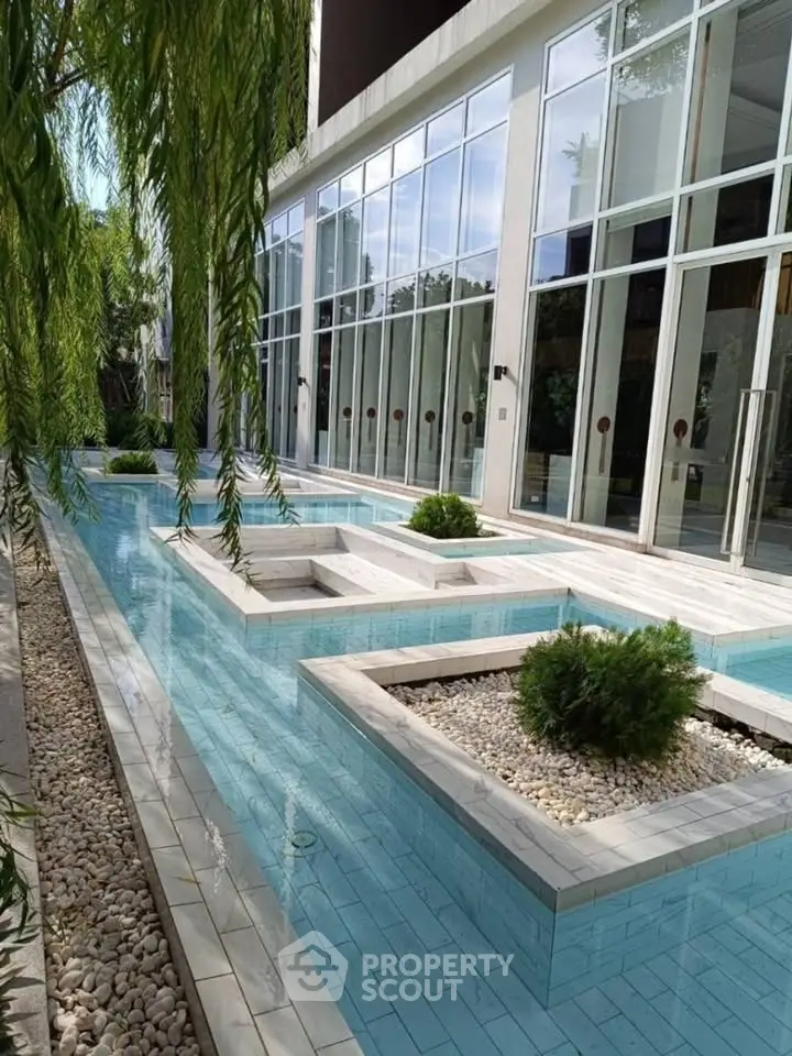 Luxurious modern building with elegant water feature and lush greenery