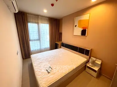 Modern bedroom with large window and stylish decor in a contemporary apartment.